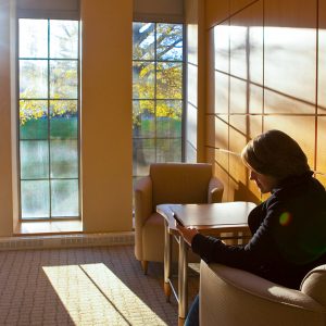 A students reads in an alcove as the sun sets through the windows of Oechsle Hall