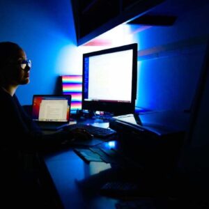 Nadia Manasfi ’23 works at a brightly lit computer screen in a dark room